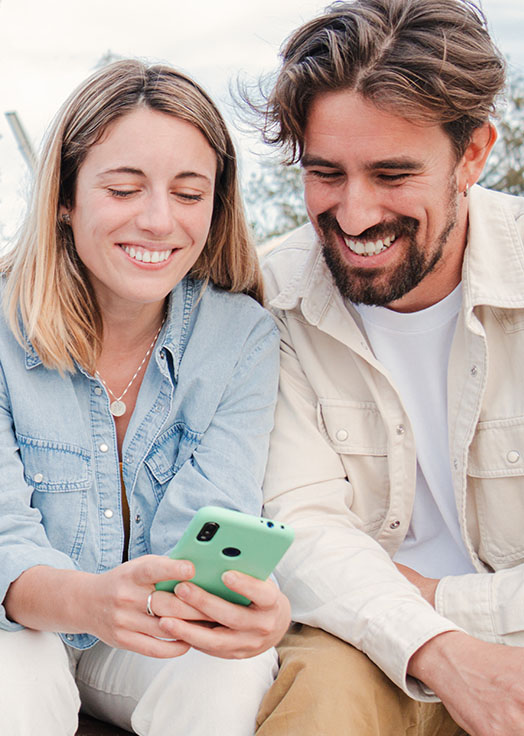happy couple looking at a smartphone